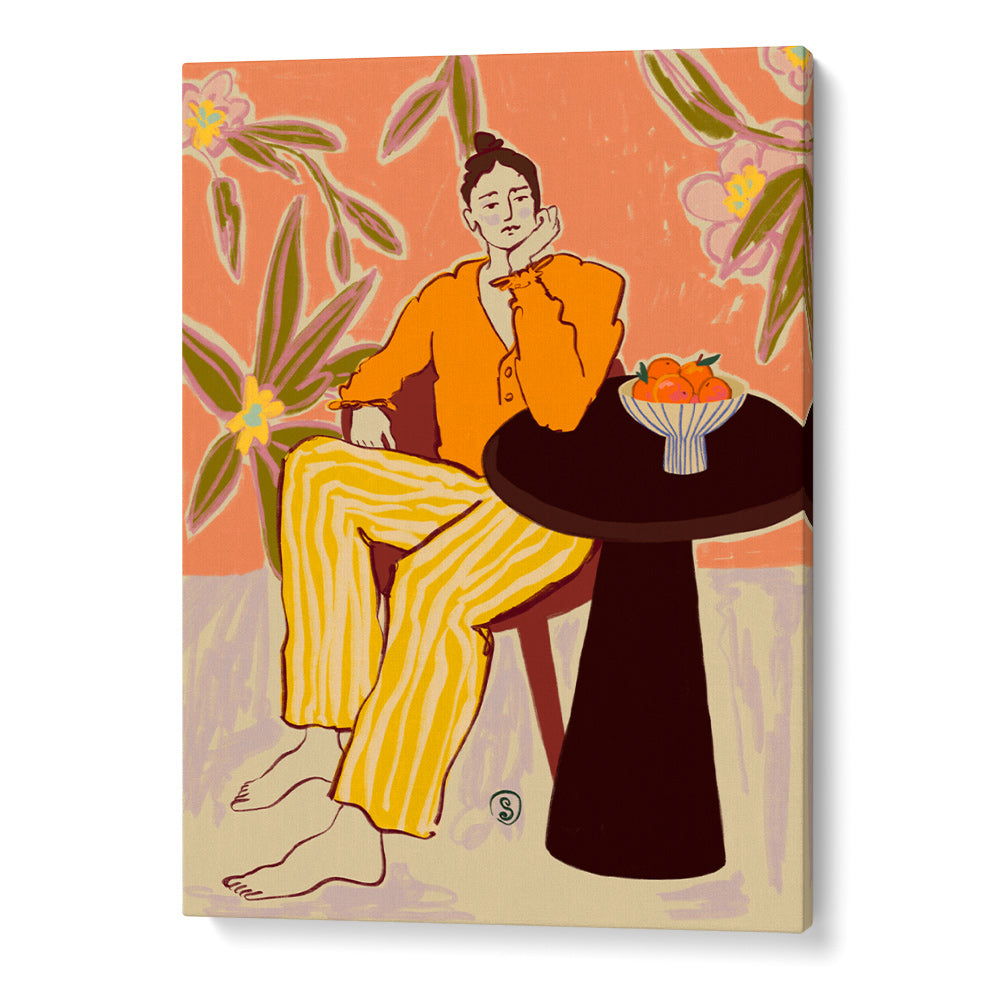 Canvas print of a woman in an orange top and yellow pants sitting at a table with a bowl of fruit, surrounded by floral elements.